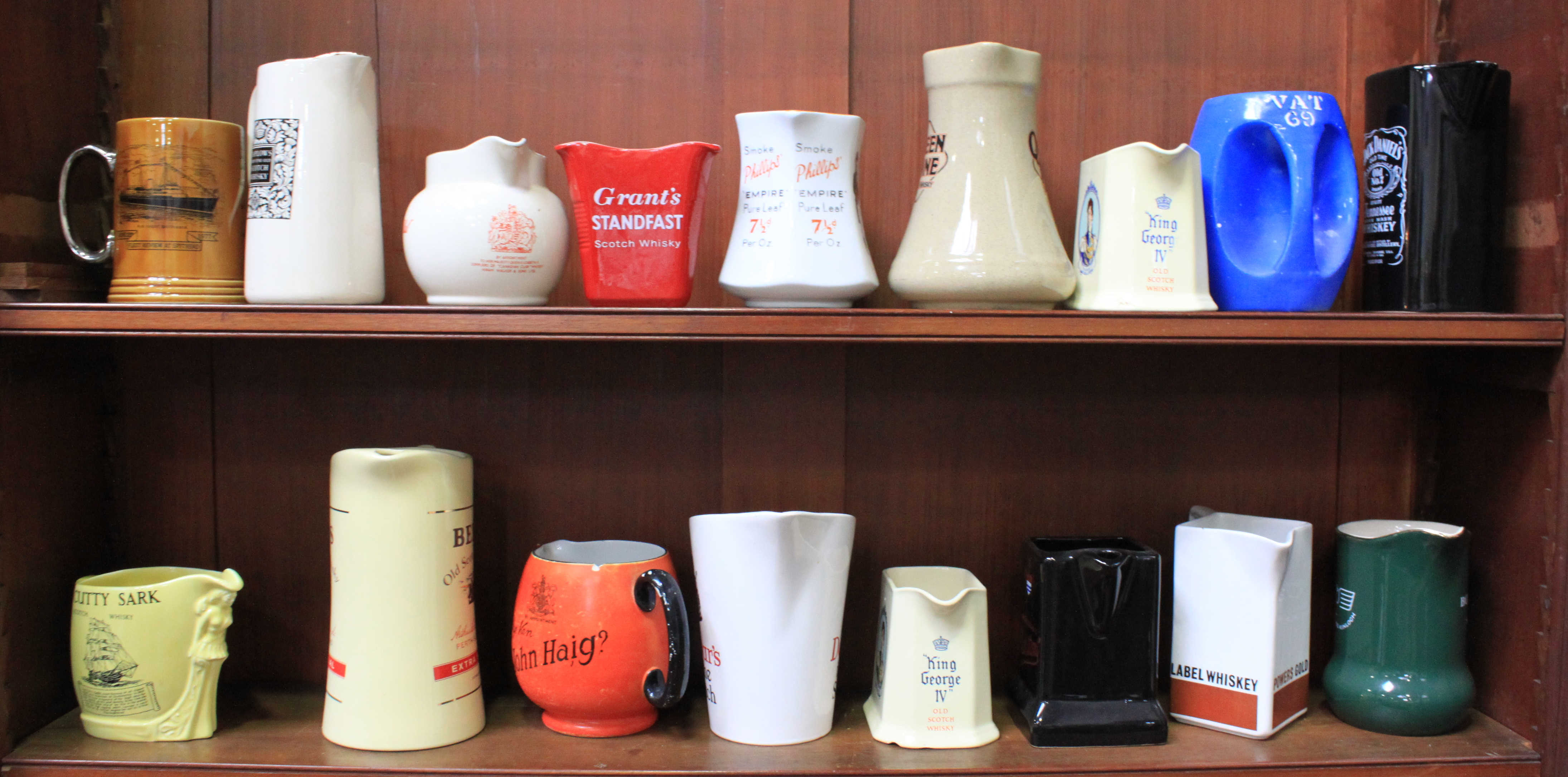 A collection of seventeen ceramic whisky jugs including some 'Wade' and 'Burleigh Ware' pieces,