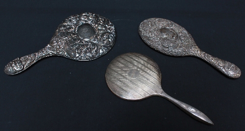Three various silver backed hand mirrors.