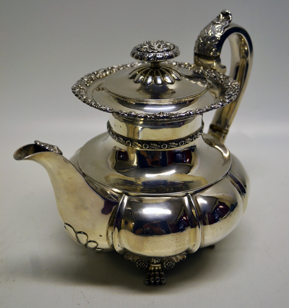 A George IV silver coffee pot, the part everted melon panelled body engraved a crest of a wading