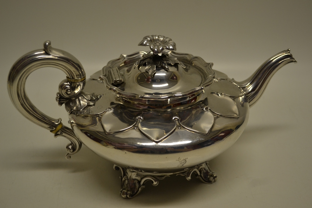 A William IV silver teapot, the body engraved a crest and initials, a petal shoulder and a fluted