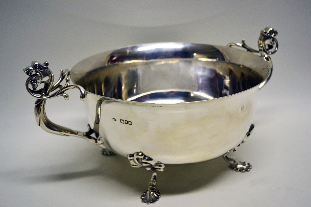 A late Victorian silver punch bowl, with cast griffin head tendril foliage scroll moulded handles,