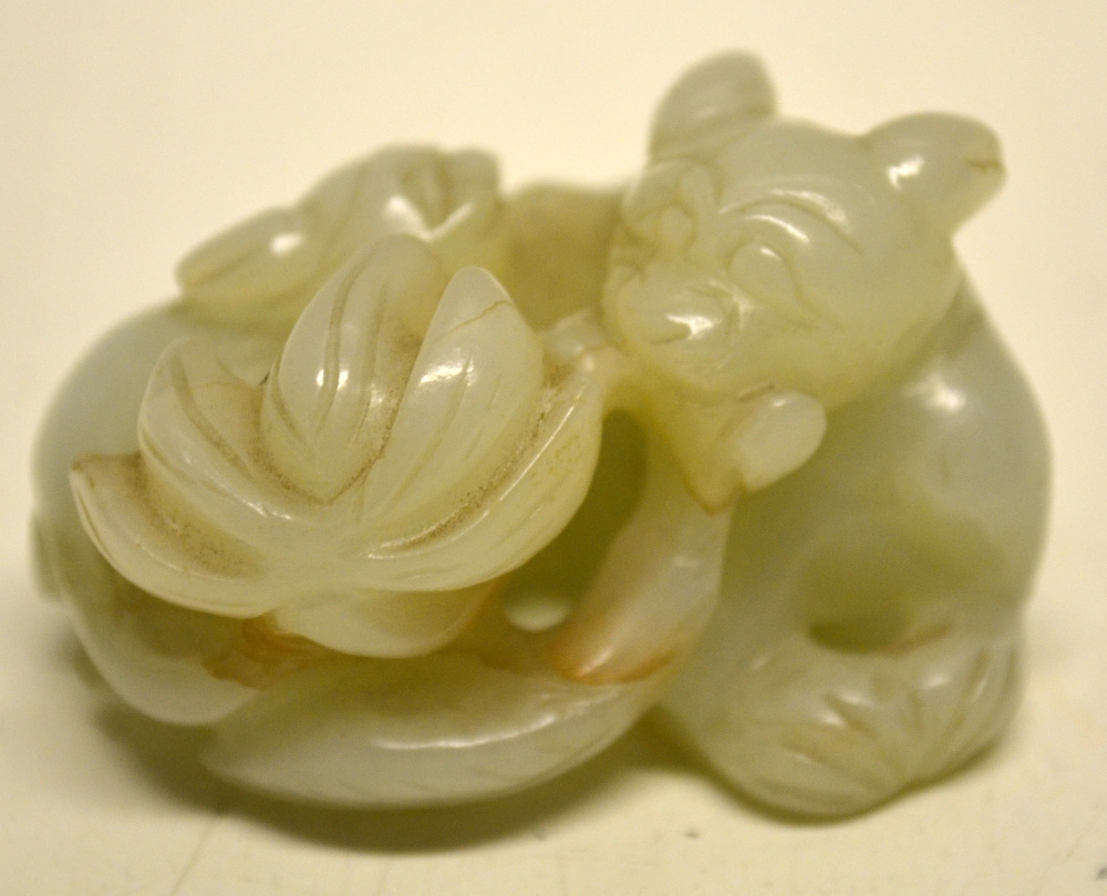 A nineteenth century Chinese mutton fat jade carving of a cat and a kitten by a plant. 2in (5cm.)