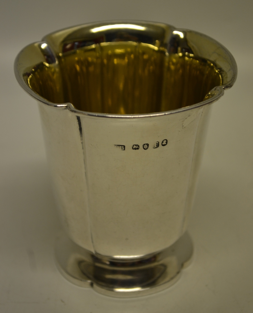 A George IV silver panelled beaker, with flared lip and a gilded interior, on a conforming foot. 3.