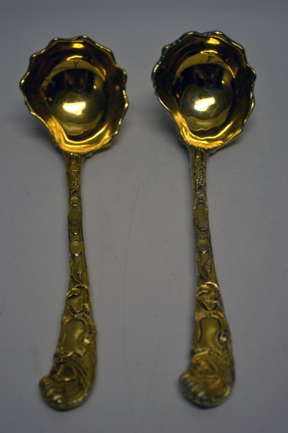 A chased silver gilt pair of copy rococo sauce ladles, in the manner of Paul de Lamere. Makers C.