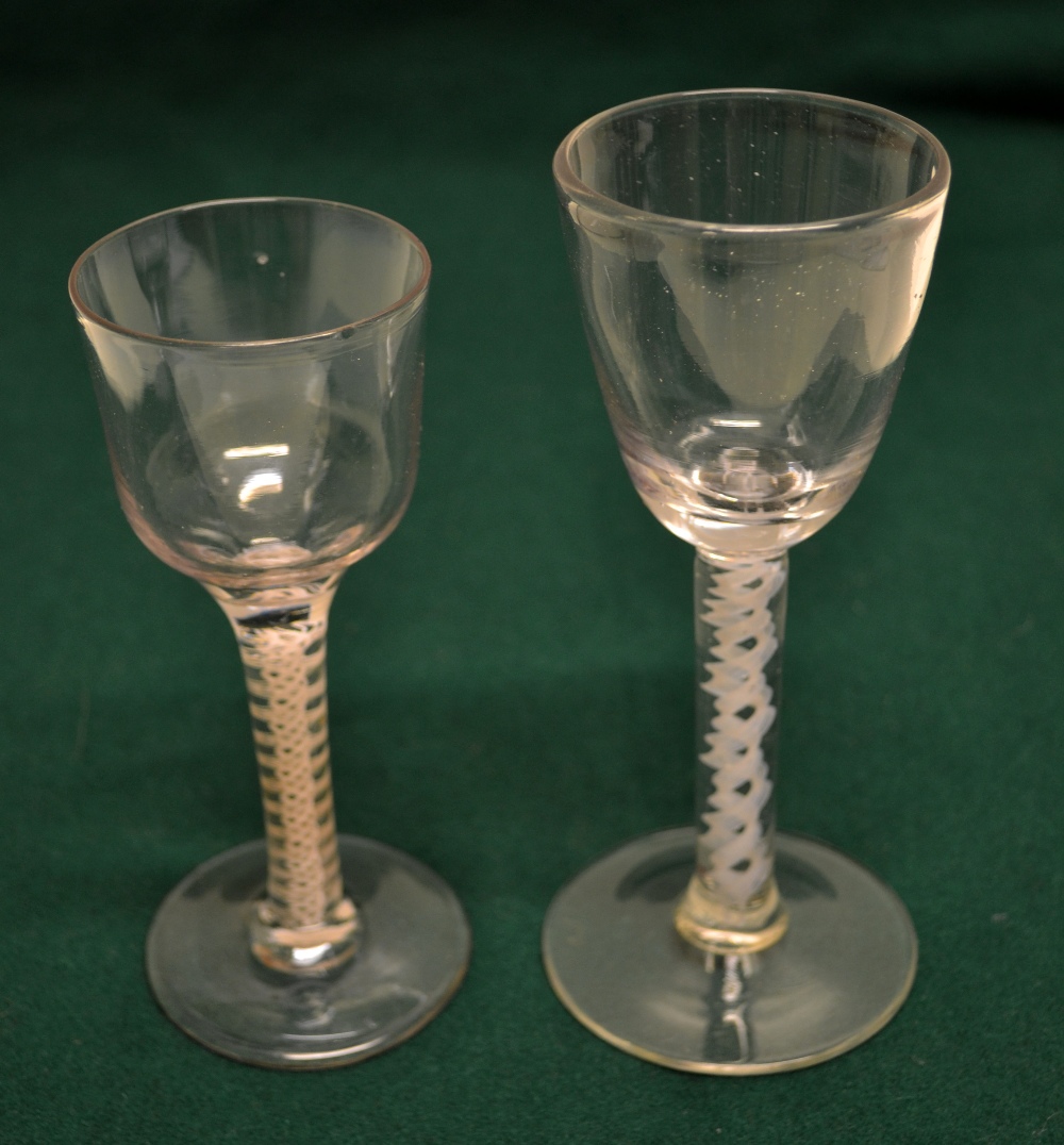 Two eighteenth century wine and cordial glasses, with collar twist stems on a circular foot, one