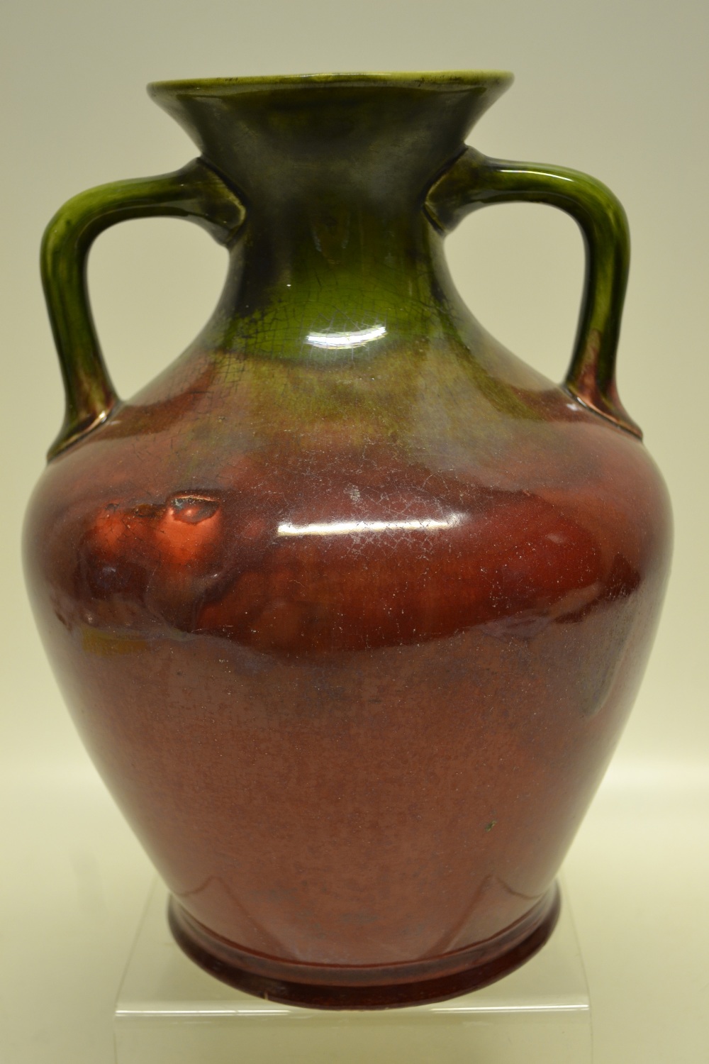 A Vodrey Dublin pottery Amphora design, two handled vase, the blood red glazed body with a green