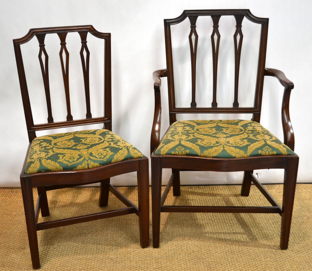 A set of seven mahogany dining chairs, Sheraton design with carved vertical rail backs with shaped