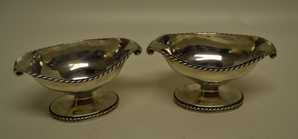 A pair of George III silver elliptical pedestal salts, with cable borders and cast husk lifts,