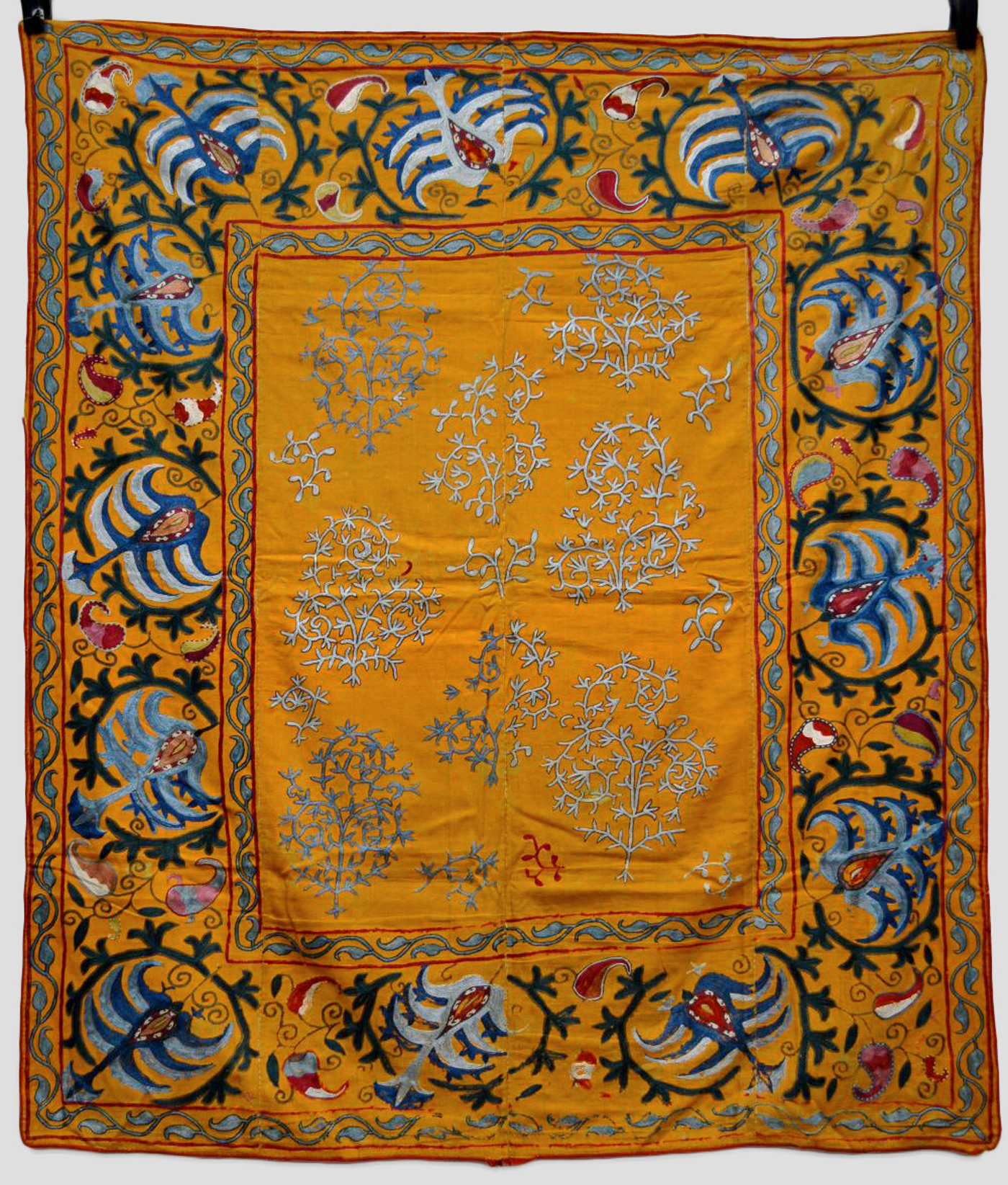 Fine Uzbek suzani, deep apricot cotton ground embroidered in coloured silks with pale blue floral