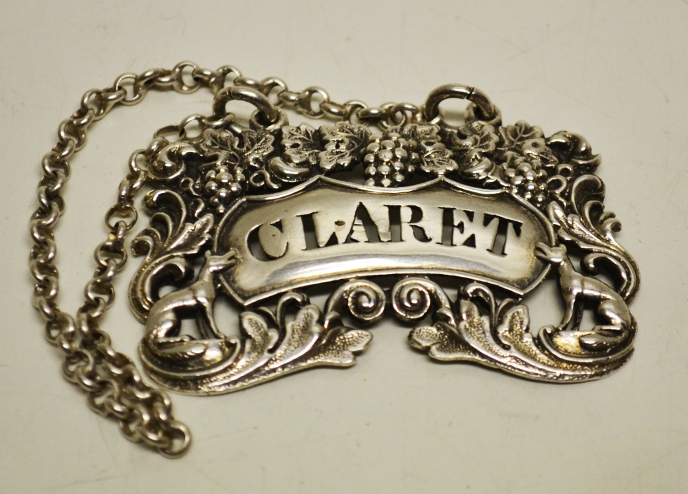 A Irish Regency cast silver wine label, pierced for claret with a pierced border of scrolling