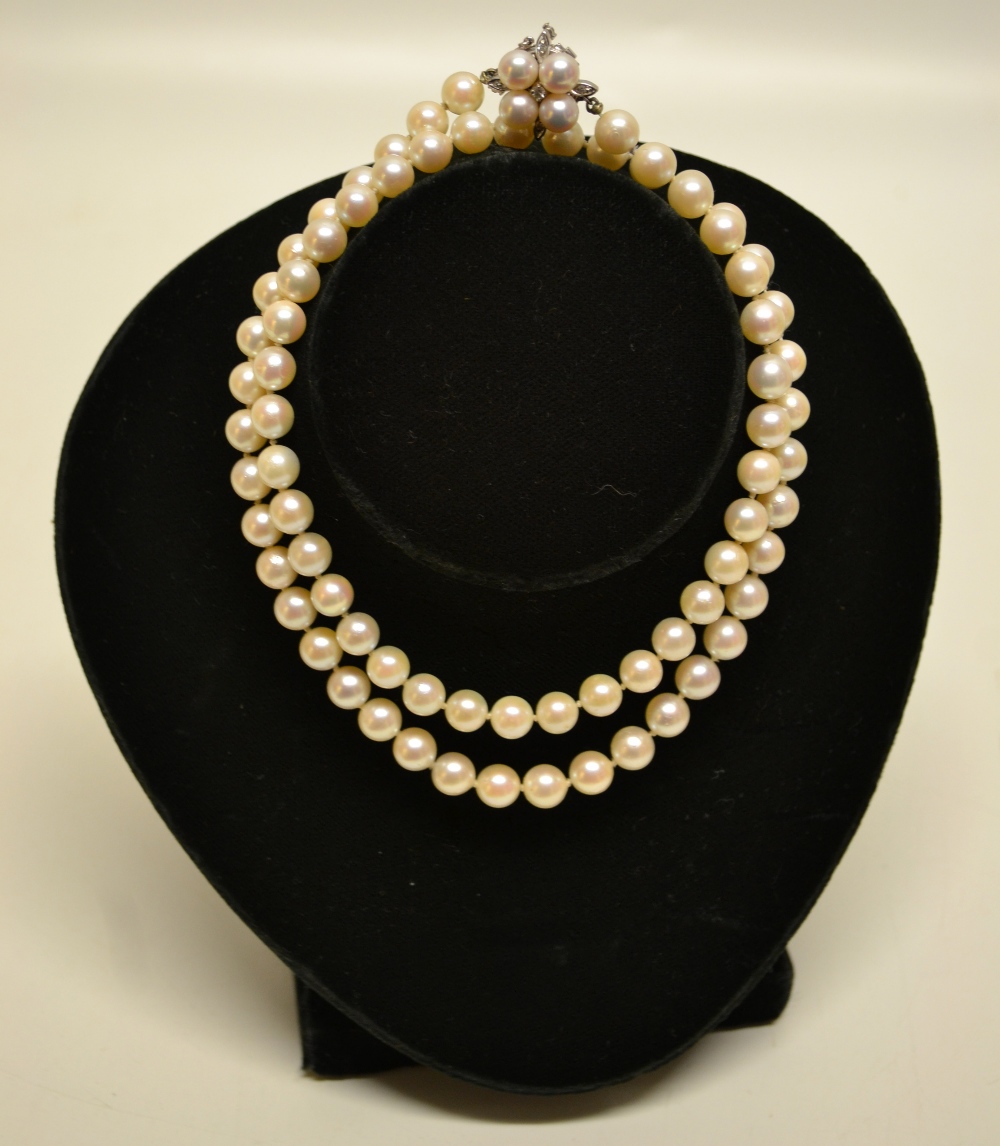 A pearl necklace, with pearl and diamond set white gold pierced clasp. (Numbered.)