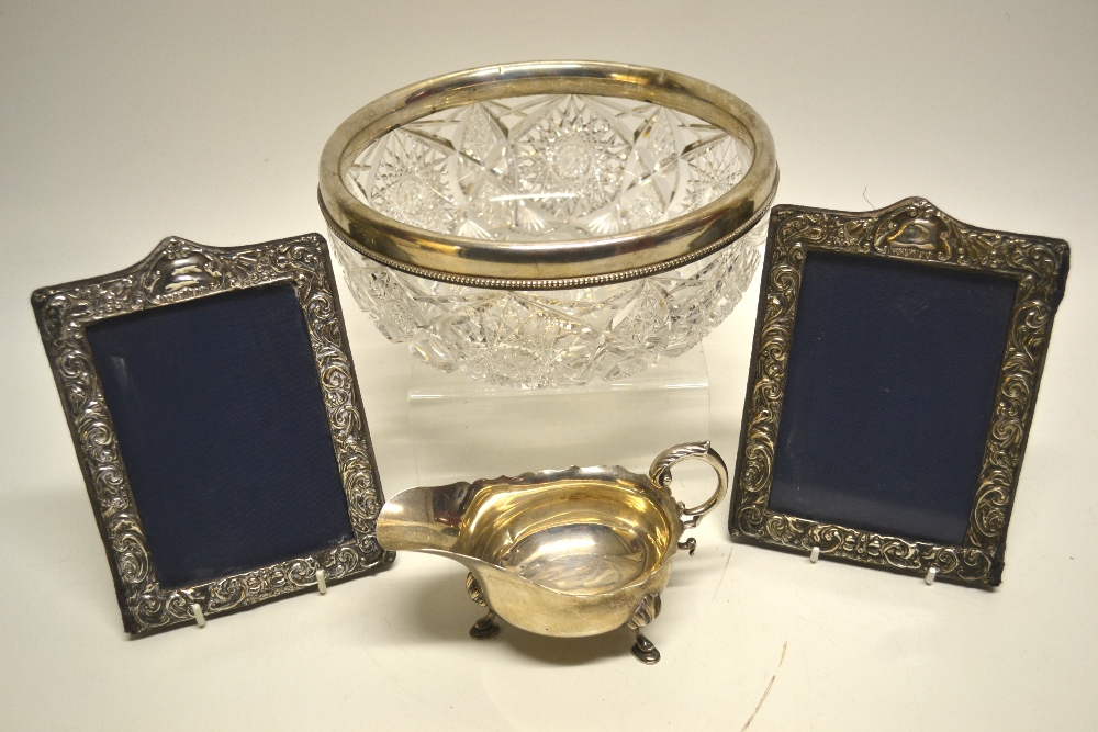 An Edwardian oval silver sauce boat, with a fret edge, flying leaf capped handle and shell appliqué