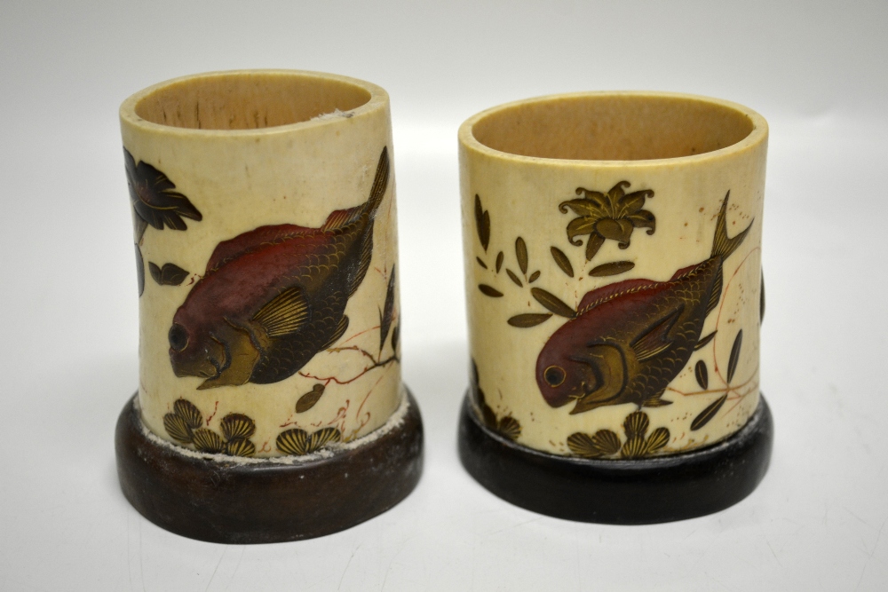 Two nineteenth century Japanese ivory tusk spill vases, decorated lacquer carp and foliage, on oval
