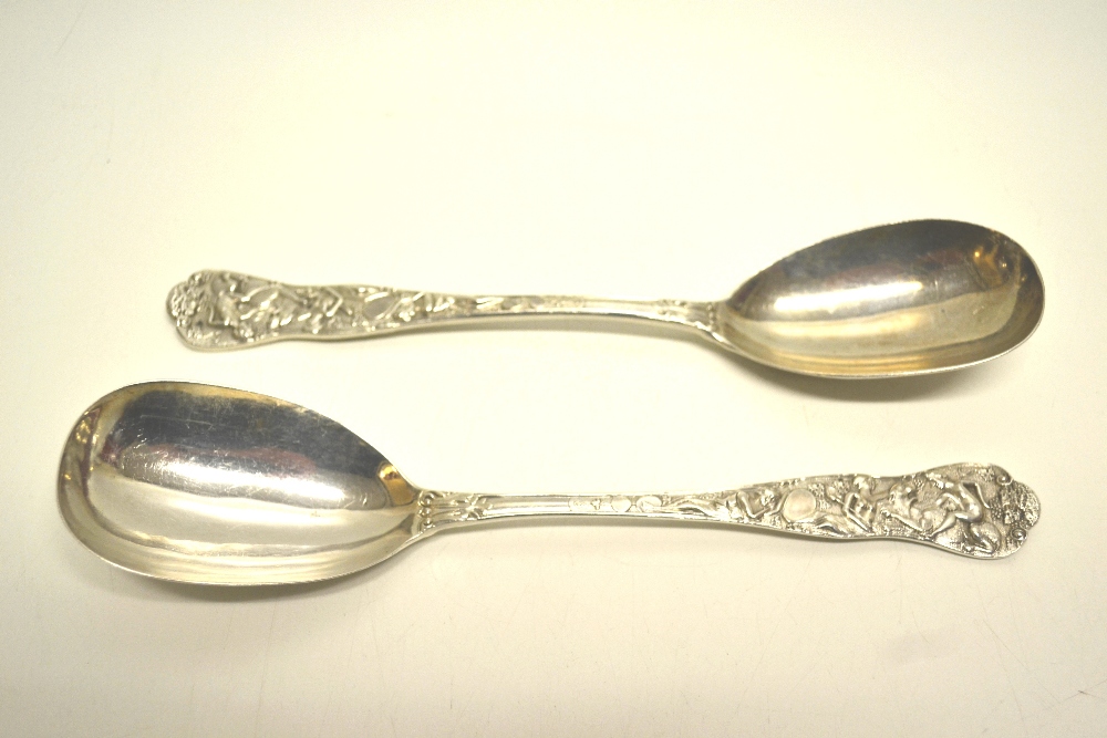 A pair of Victorian silver dessert serving spoons, with Classical design cast handles chased in the