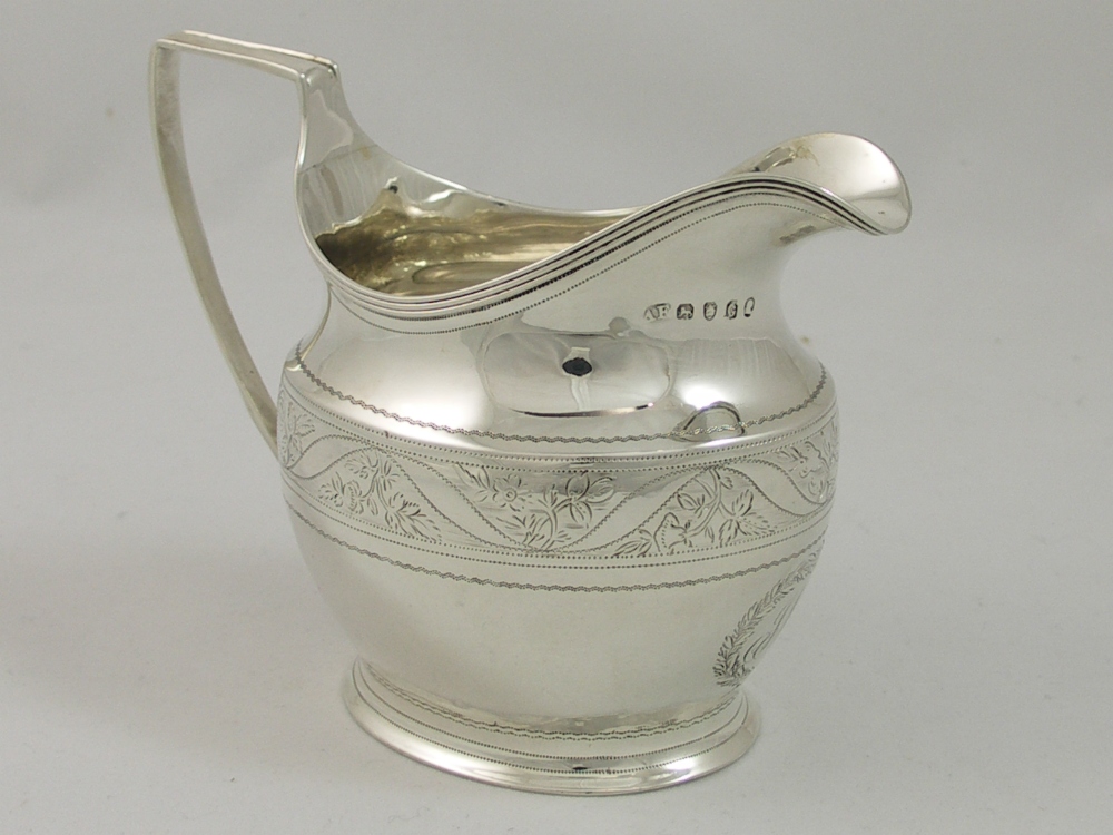 A George III milk jug with reeded border and angular handle the body engraved with initials within a