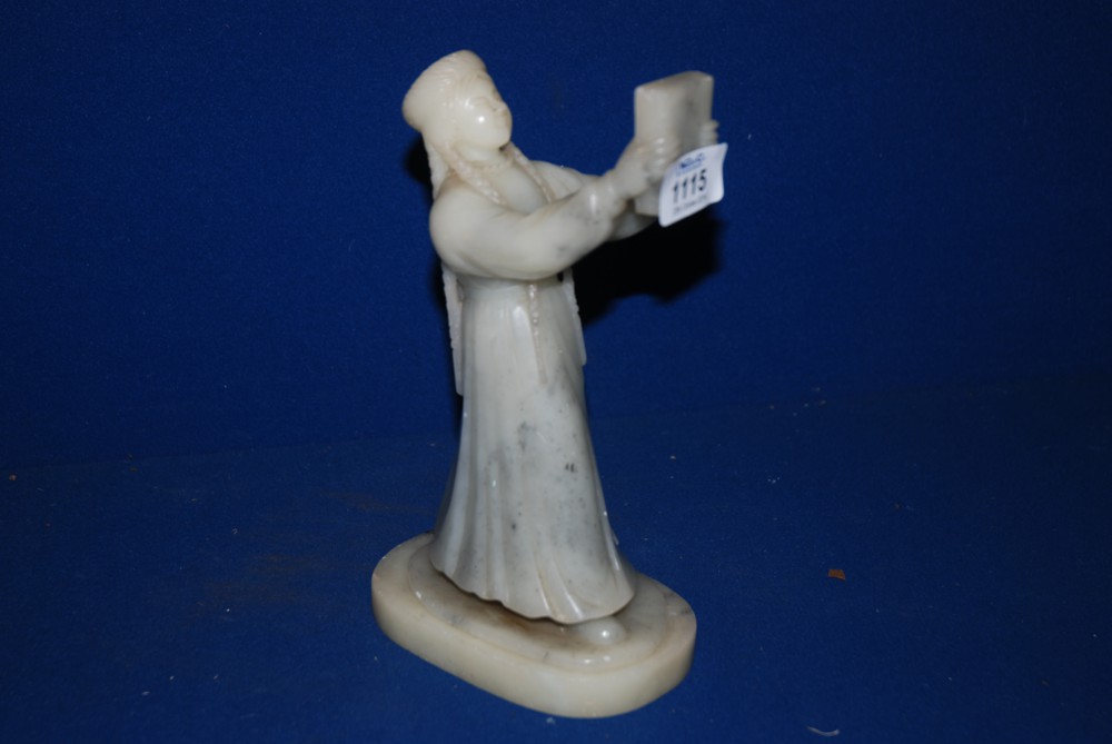 A figurine of a young Lady holding a book carved from alabaster