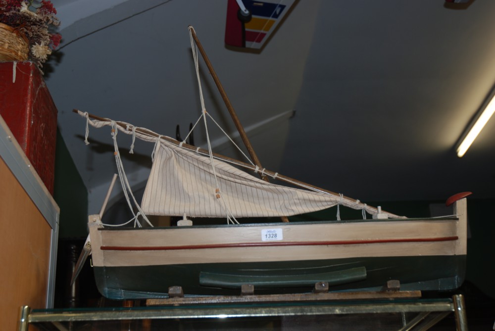 A model sailing Boat painted in green, cream and red, 28'' long, complete with stand