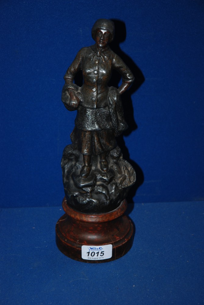 A Spelter/bronze casting of a Lady with a basket on one arm and the other on her hip and a basket of