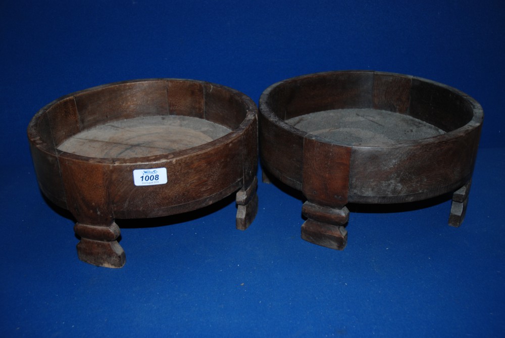 A pair of round wooden Plant Stands on legs.