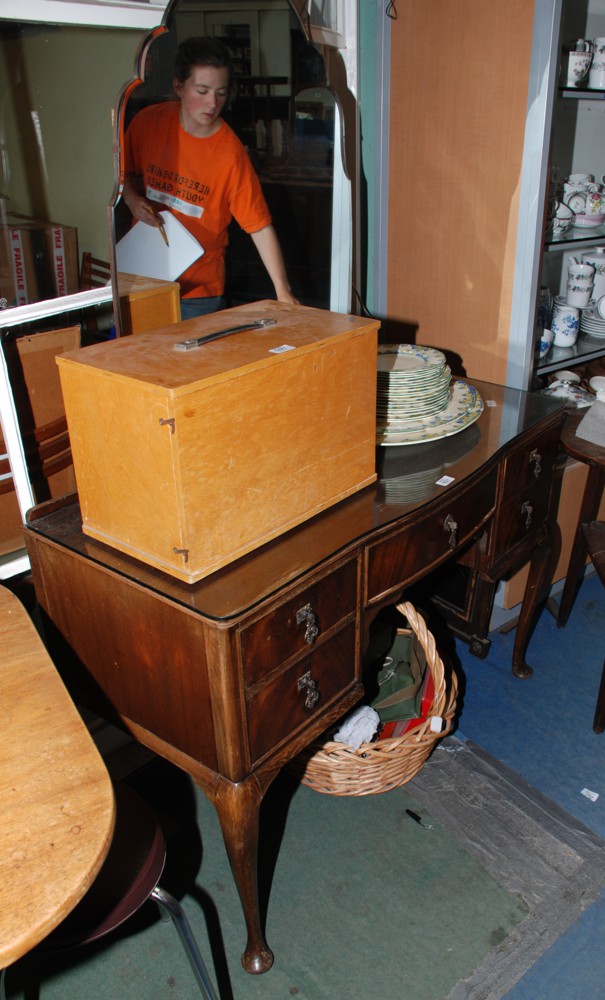 A 1950's Walnut finished Dressing Table, having shaped bevel plated mirror, fitted glass cover,