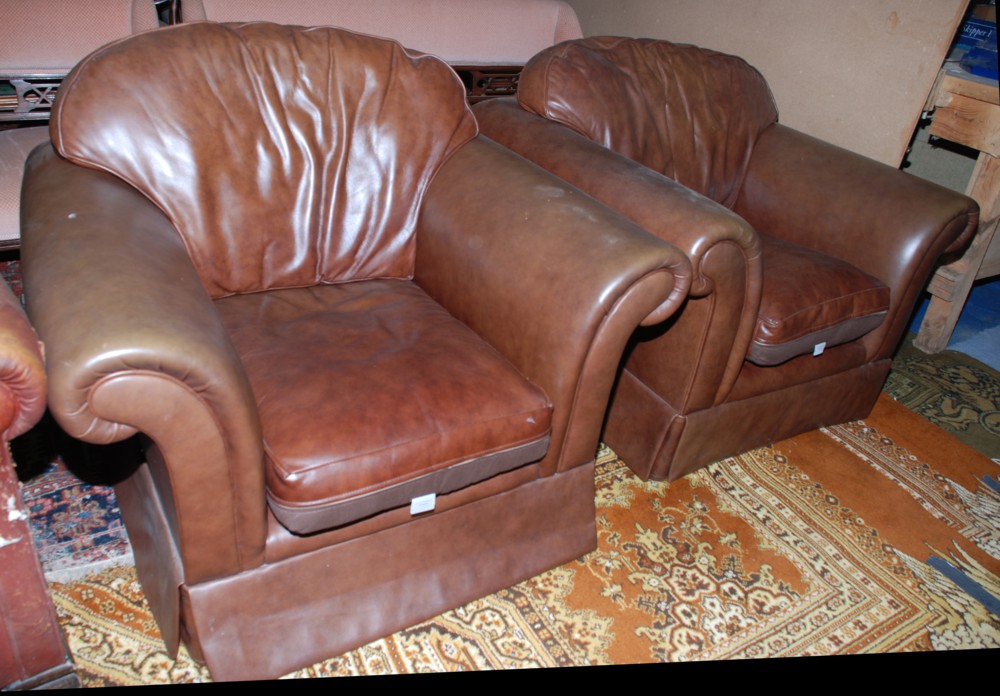 A modern pair of brown leather look Armchairs with wide deep seats.