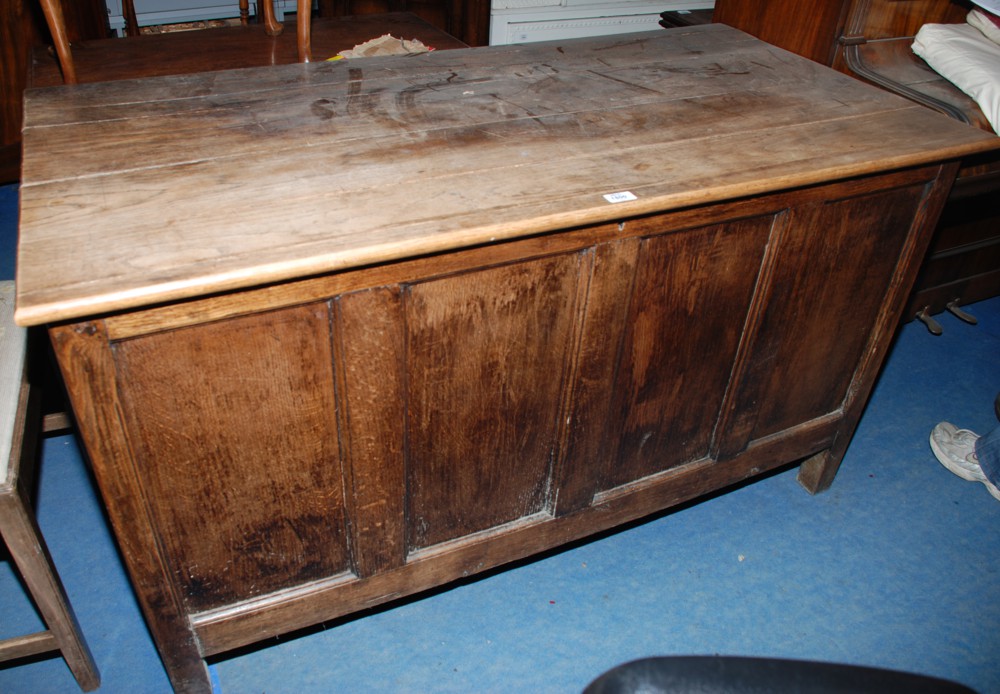 A reproduction Oak Coffer, having five plank top with four panel front and two panel ends.  54 1/