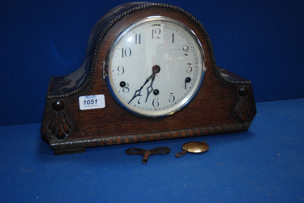 A wooden cased chiming Mantle Clock with pendulum and key