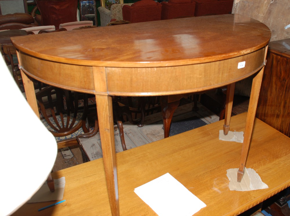 A Georgian light Mahogany demi-lune Hall Table having plain top, and lower moulding to the frieze