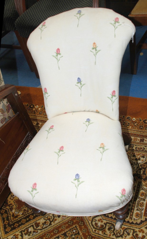 A 19th c. low Nursing Chair, upholstered in cream fabric with flower print design, standing on