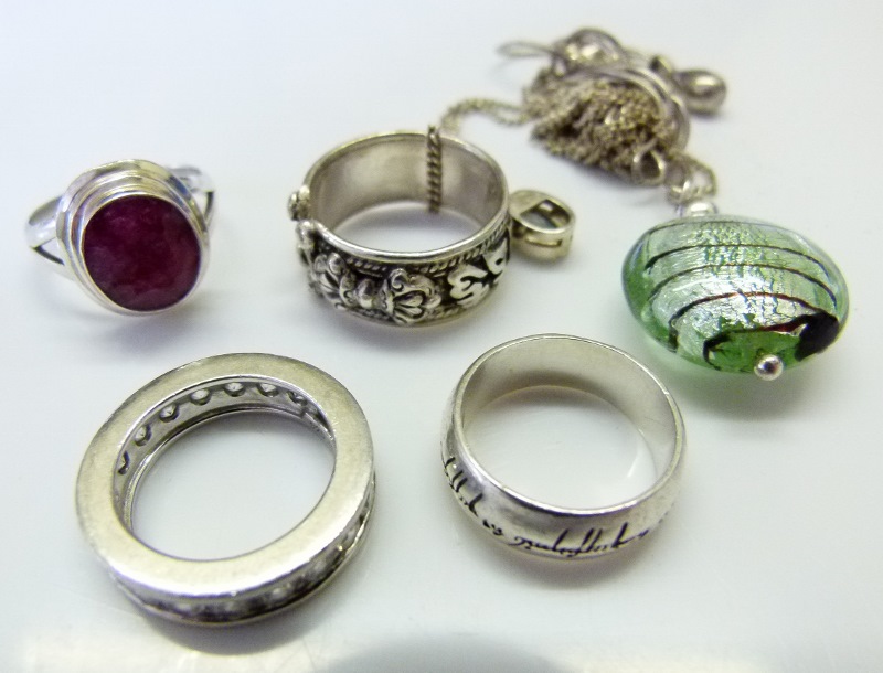 Four silver rings including Lord of the Rings example and four pendants on silver chains.