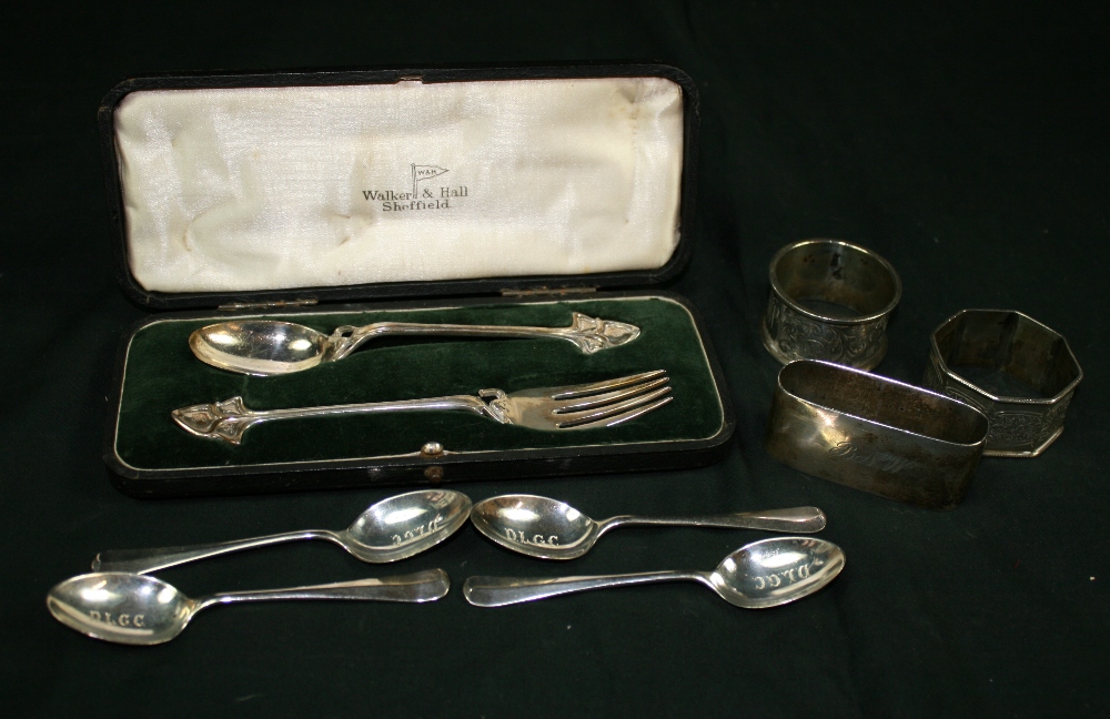 NAPKIN RINGS/ SPOONS - A collection of 3 napkin rings, 4 teaspoons and a cased spoon and fork set to