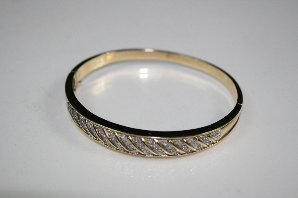 GOLD / DIAMOND BANGLE - A 9ct gold and diamond bangle in Mount Royal box. Total weight16.7g.