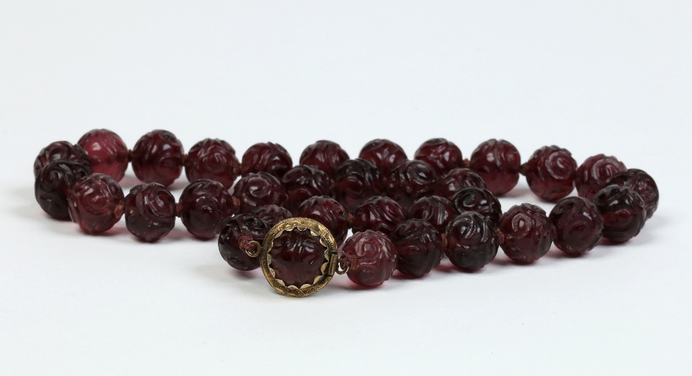 An early twentieth century Chinese string of carved amethyst beads with silver clasp. 46cm long.