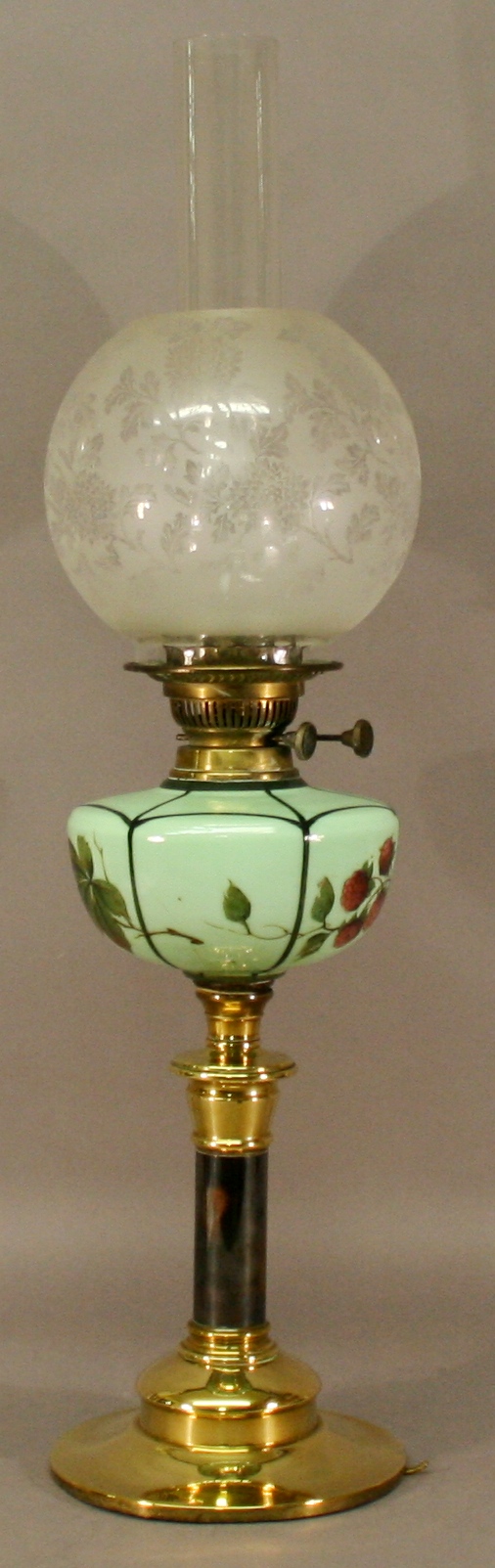 A VICTORIAN BRASS AND GLASS OIL LAMP having a clear glass chimney, globular etched glass shade, `