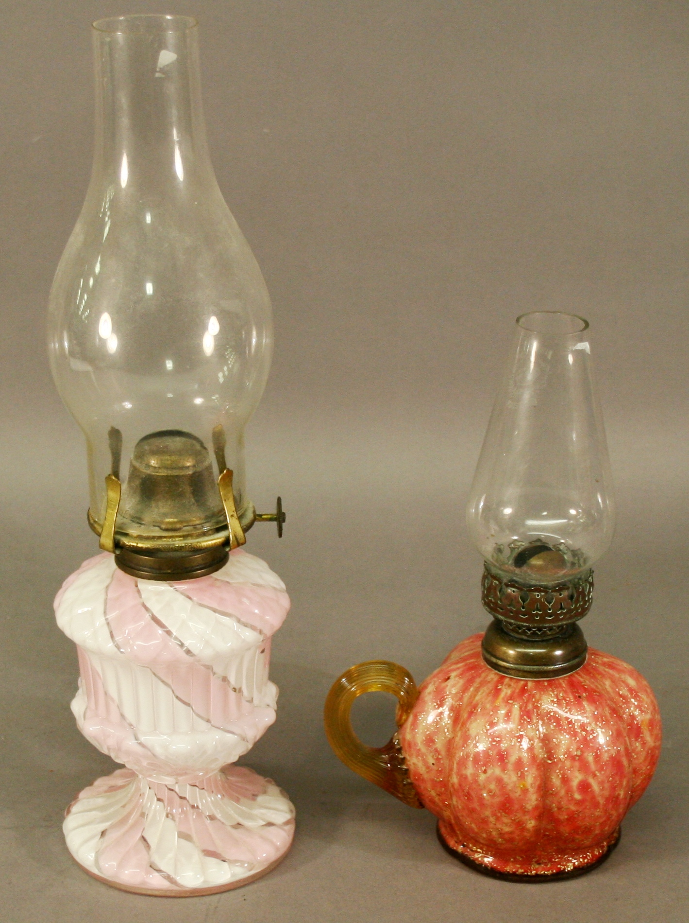 A VICTORIAN GLASS HAND-HELD OIL LAMP of lobed pumpkin form with mottled pink colouring and