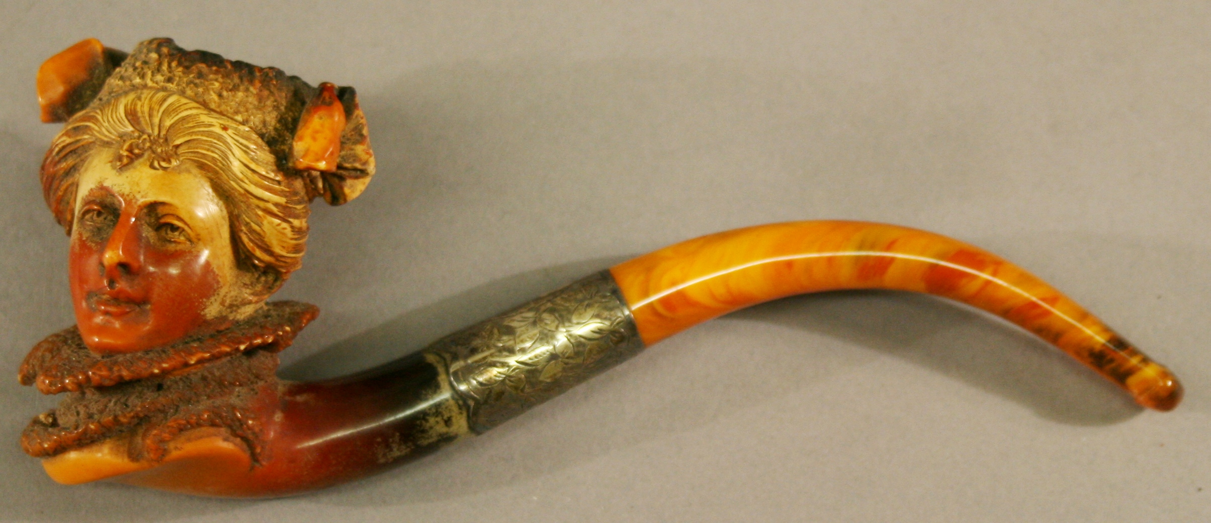 A VICTORIAN CASED MEERSCHAUM PIPE, the bowl finely carved as a females head, the shank leading to a