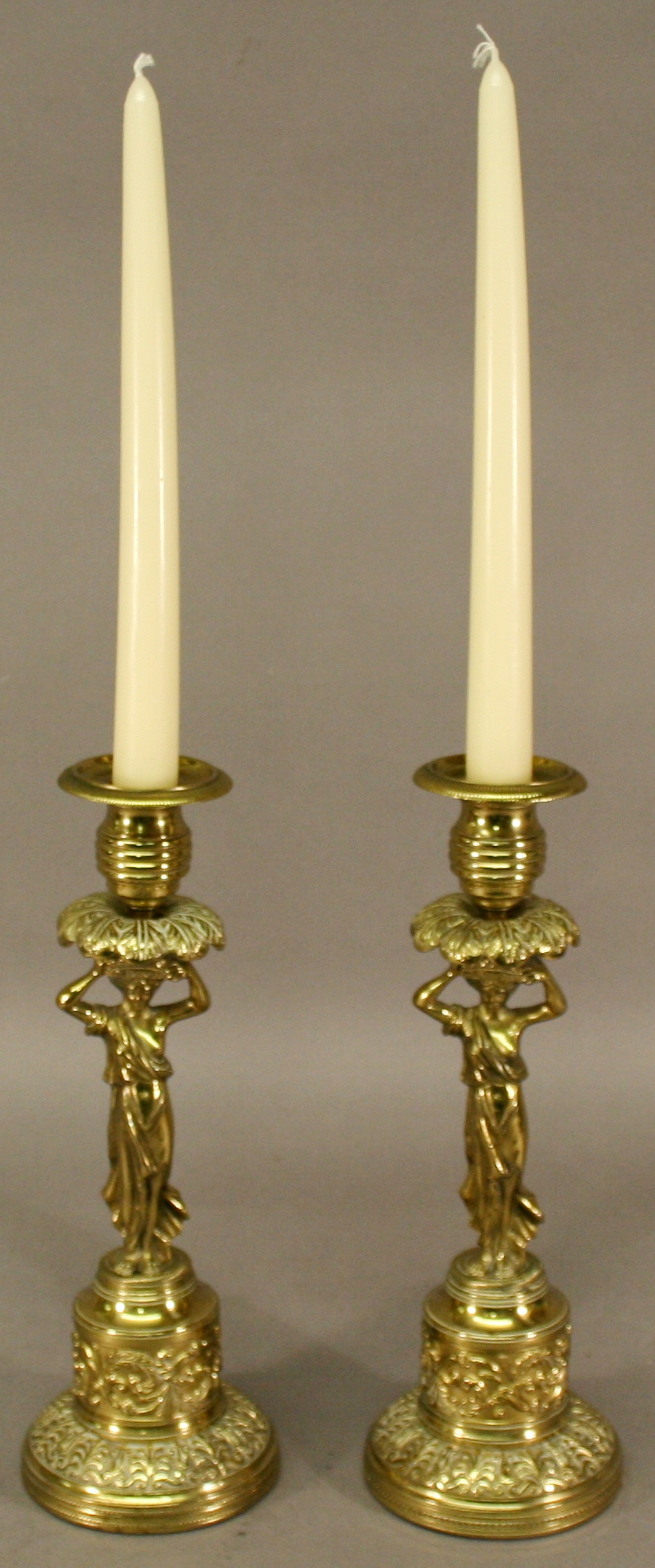 A PAIR OF LATE 19TH CENTURY FIGURAL BRASS CANDLESTICKS having turned and gadrooned sockets with a