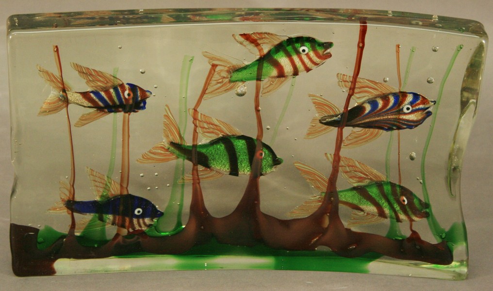A LARGE DECORATIVE MURANO GLASS BLOCK of slightly curved oblong form inset with six swimming fish,