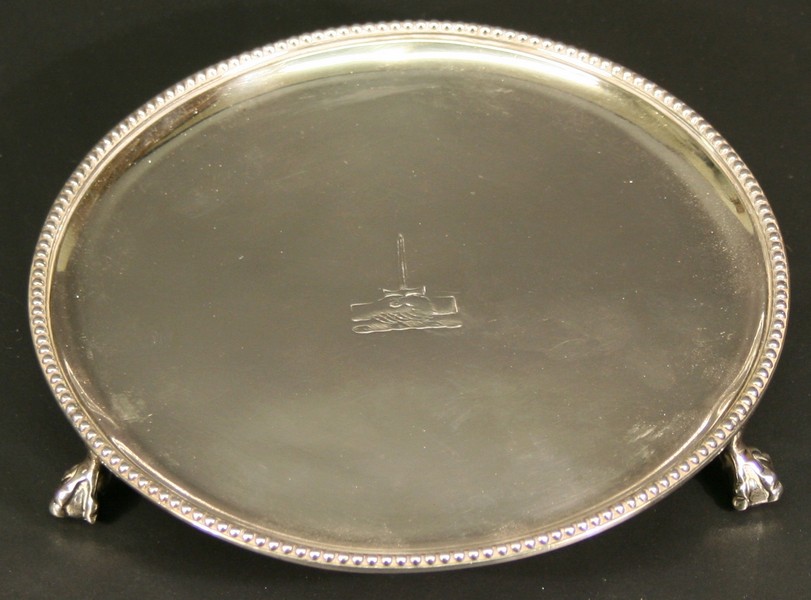 A GEORGE III SILVER VISITING CARD TRAY of circular form with bead-moulded rim and engraved crest of