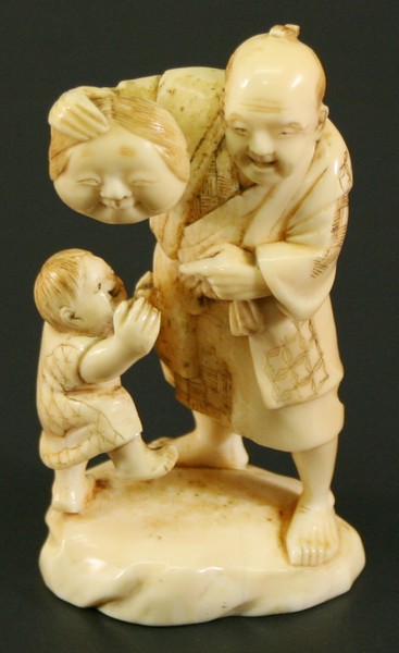 A JAPANESE CARVED IVORY OKIMONO Meiji period, formed as an elderly gentleman tormenting a young