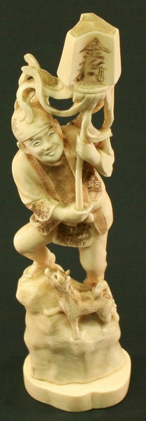 A JAPANESE CRAVED MARINE IVORY OKIMONO formed as a gentleman holding aloft a three-sided ribboned