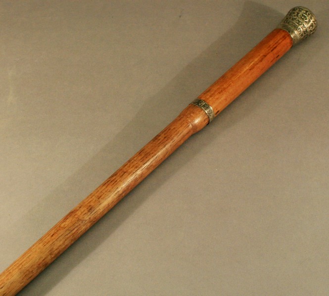 AN EASTERN WHITE METAL TOPPED MALACCA WALKING CANE late 19th century, the domed white metal top