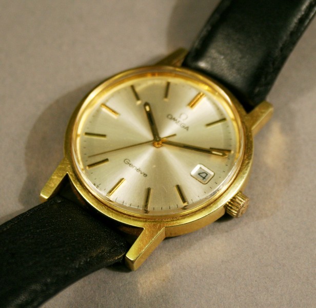 A GENTLEMANS` OMEGA GENEVE WRISTWATCH of circular form with baton hour markers and rolling date