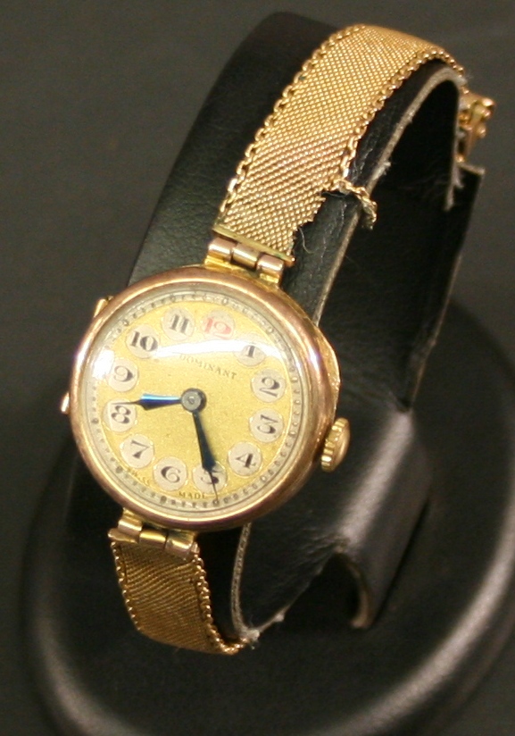 A LADIES `DOMINANT` 9CT GOLD CASED WRISTWATCH of circular form with Arabic hour roundels to the