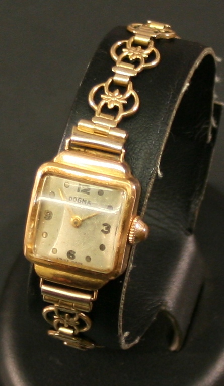 AN 18K GOLD CASED LADIES WRISTWATCH by Dogma, the square silvered dial with Arabic quarters, the