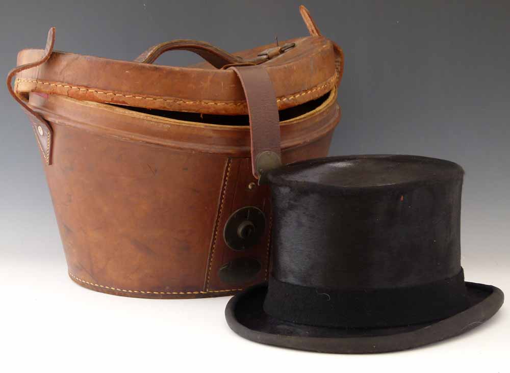 Antique brown leather top hat case containing a dressage top hat by Herbert Johnson.    Condition