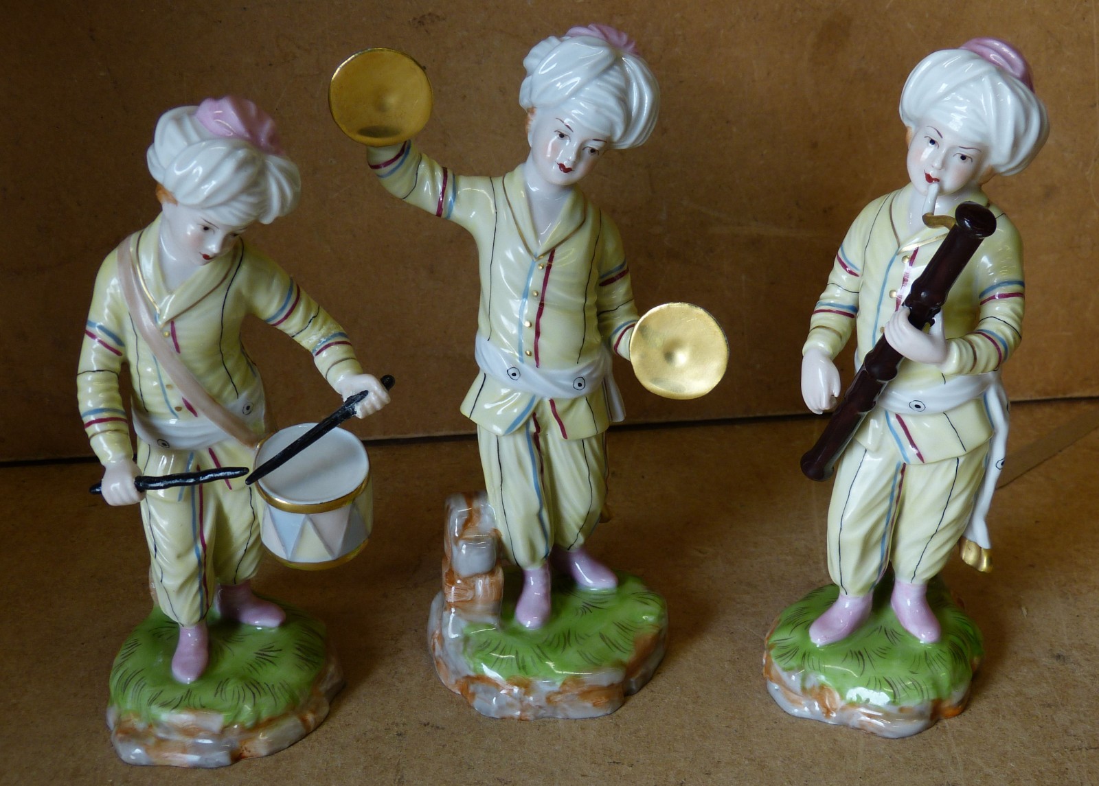 A Set of 3 Hexter China Musicians of young boys playing musical instruments on round scalloped