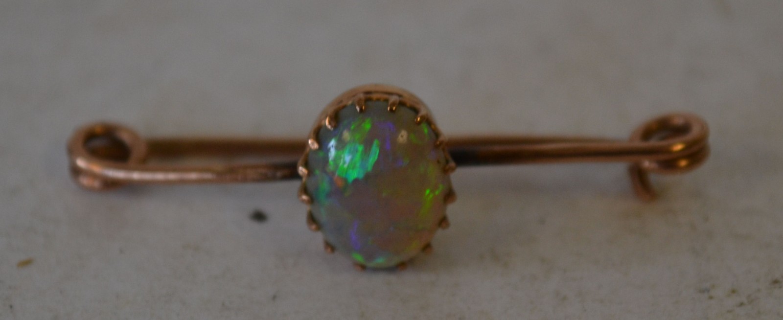 A 9ct Gold Bar Brooch, mounted with oval opal