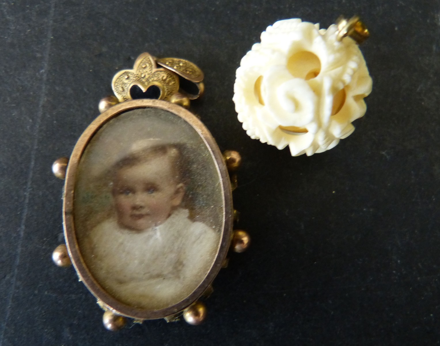 An Oval Double Sided Miniature Pendant, also small ivory charm in form of puzzle ball