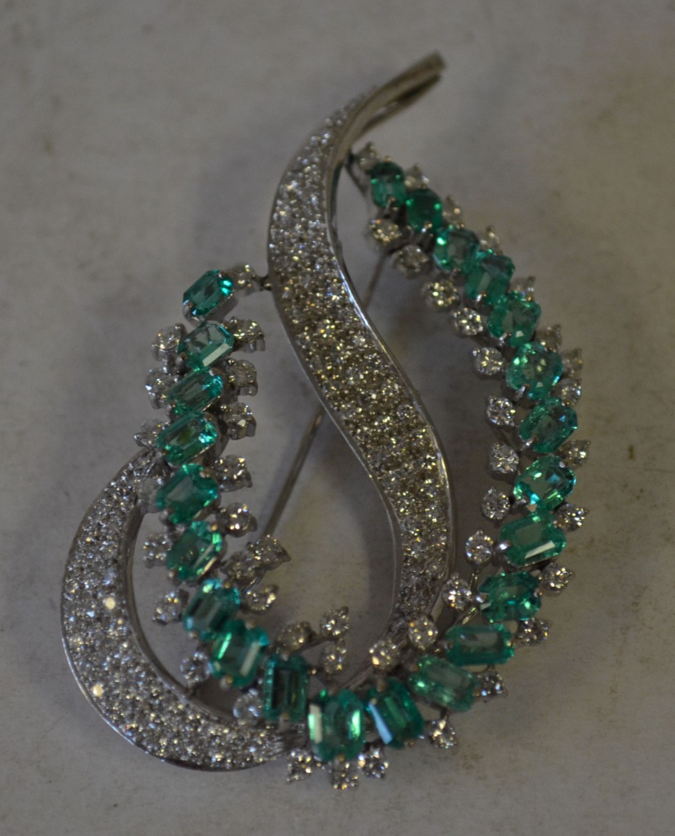 A 18ct White Gold Scroll Brooch set with all over diamonds and green stones